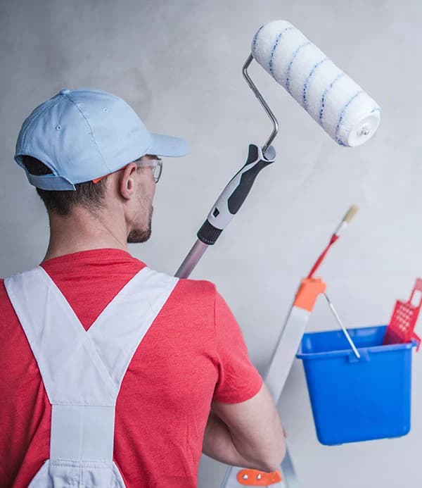 Professional painter with paint roller and bucket